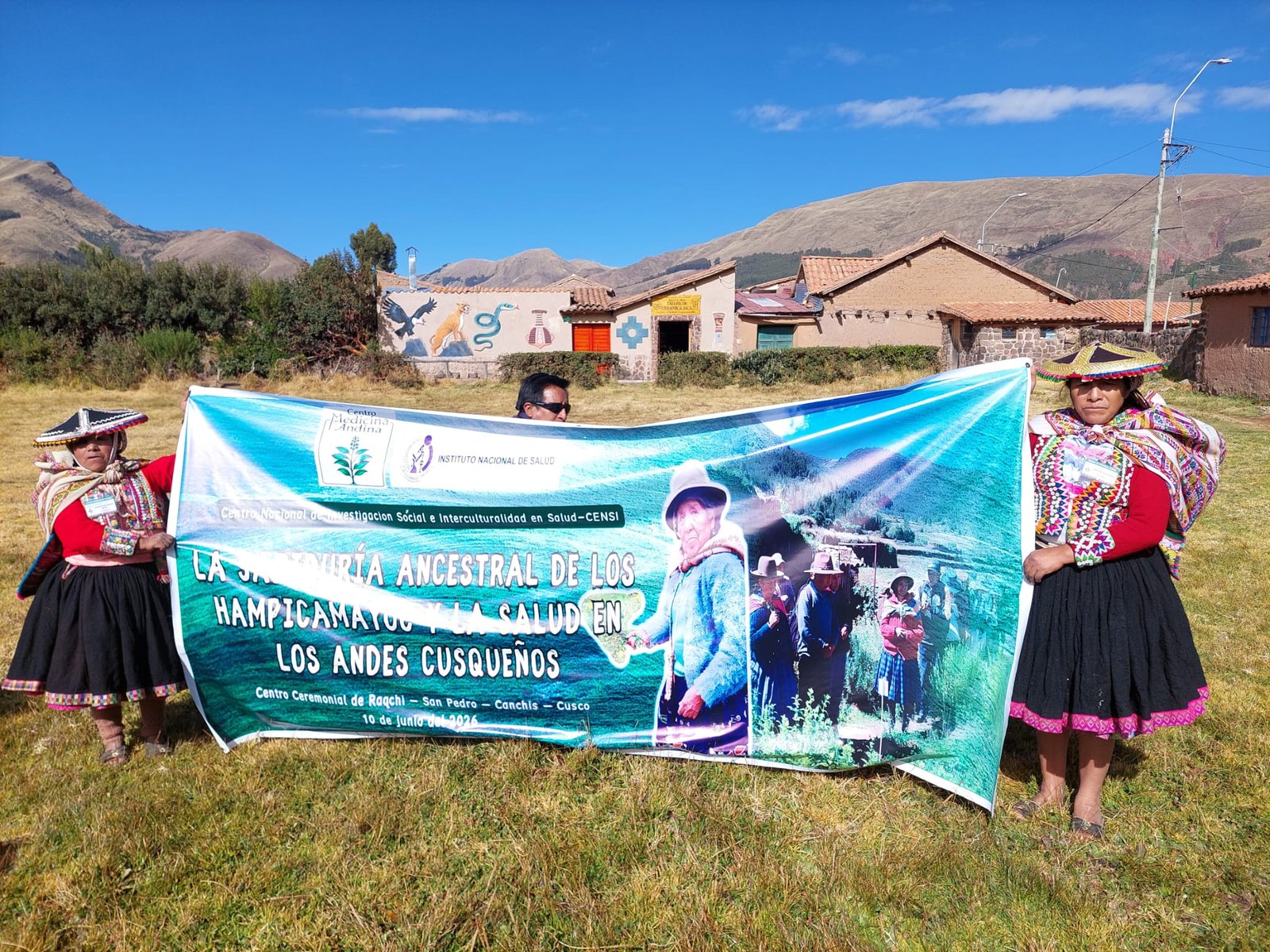 Dos mujeres sosteniendo el banner del encuentro sobre la sabiduría ancestral de los Hampicamayoc