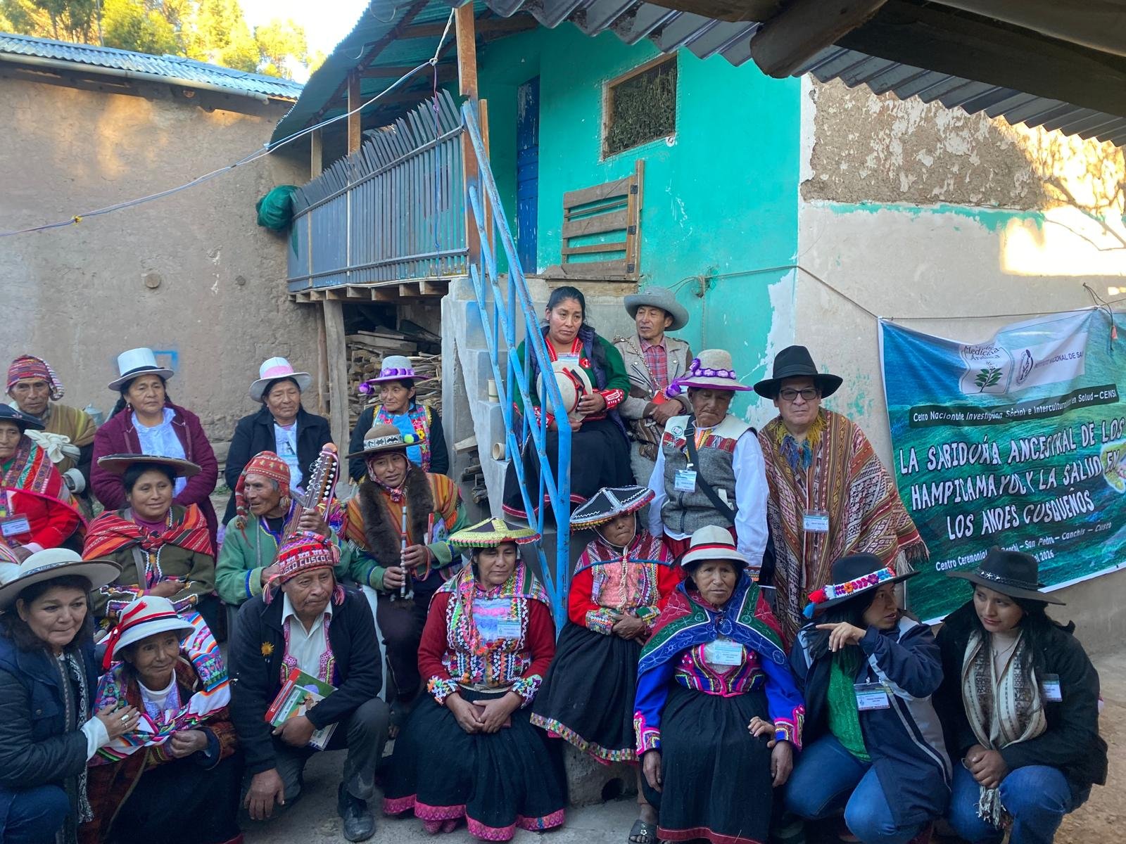 Hampicamayoc reunidos frente al banner del encuentro sobre la sabiduría ancestral y la salud en los Andes cusqueños